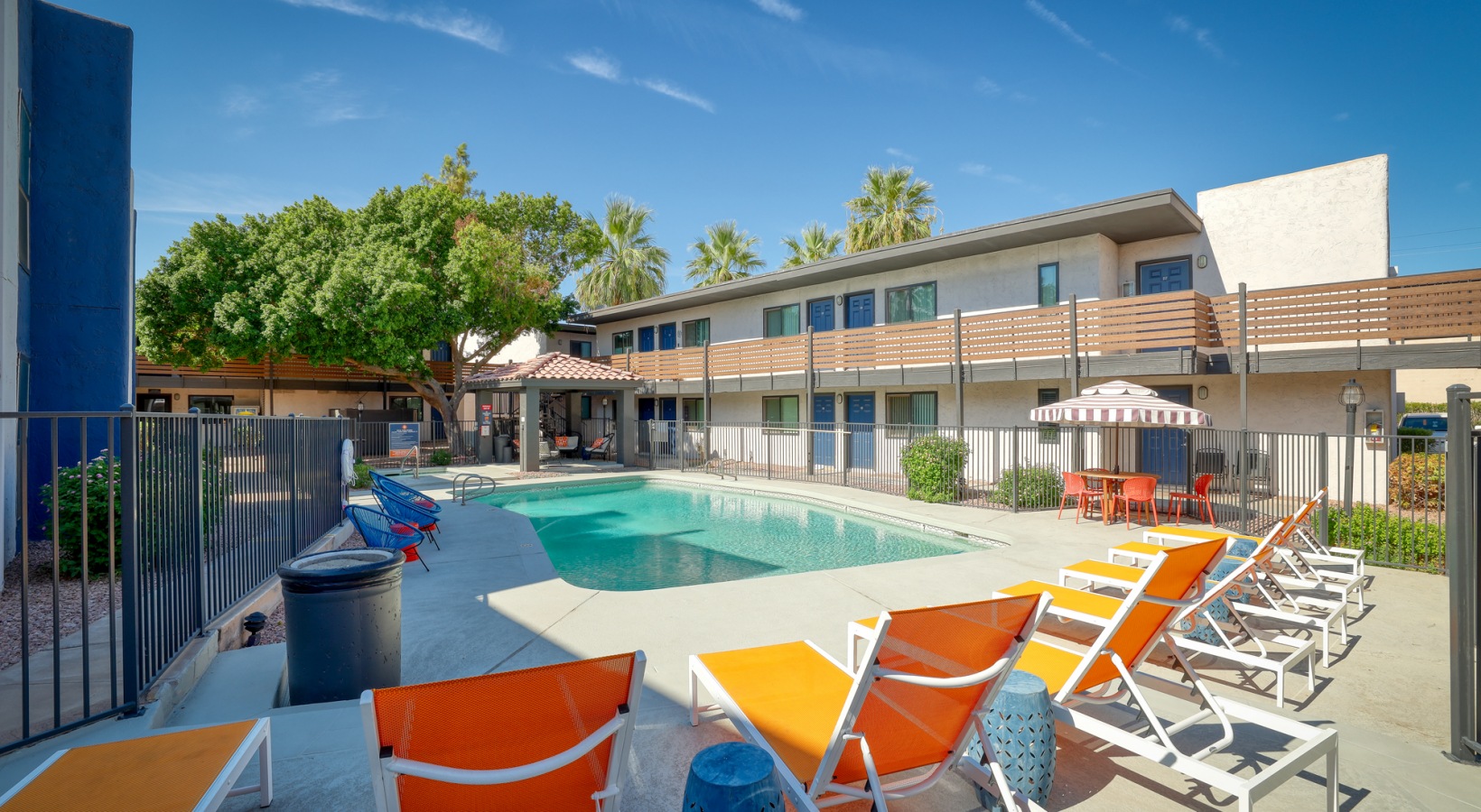 a pool and lounge chairs in front of an apartment building at The Senara