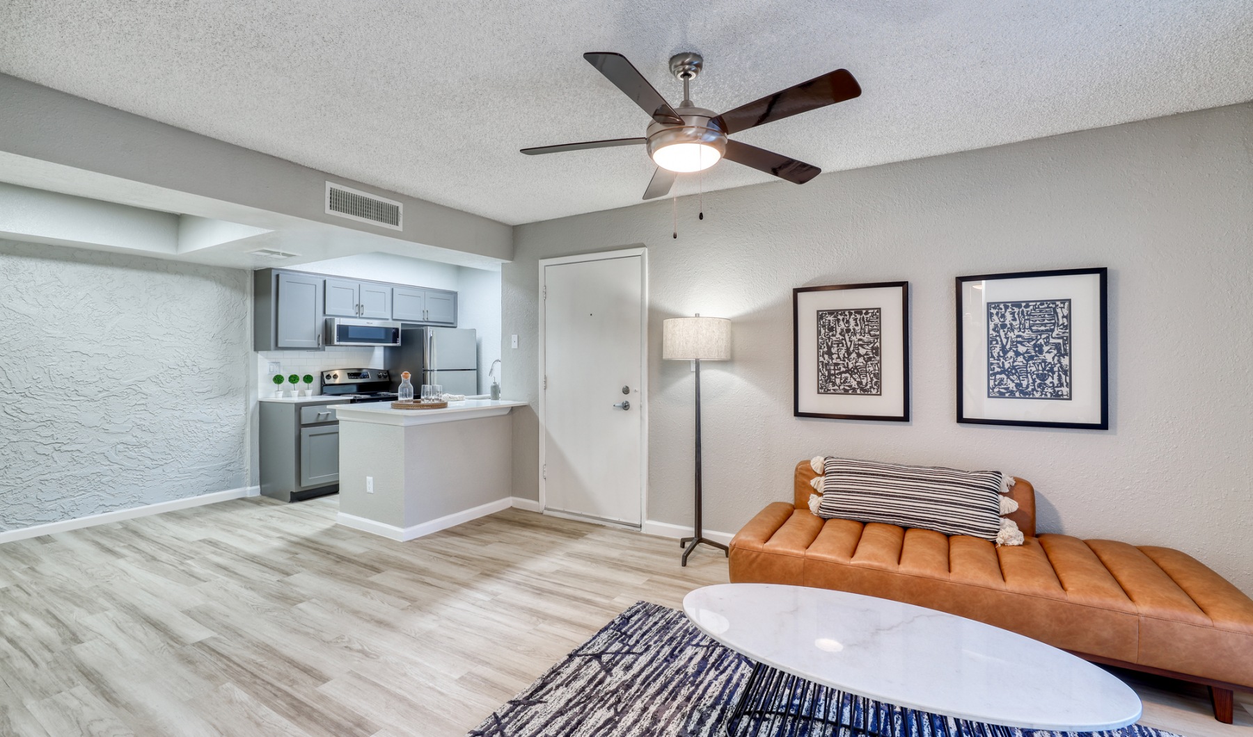 a living room with a ceiling fan and a couch at The Senara
