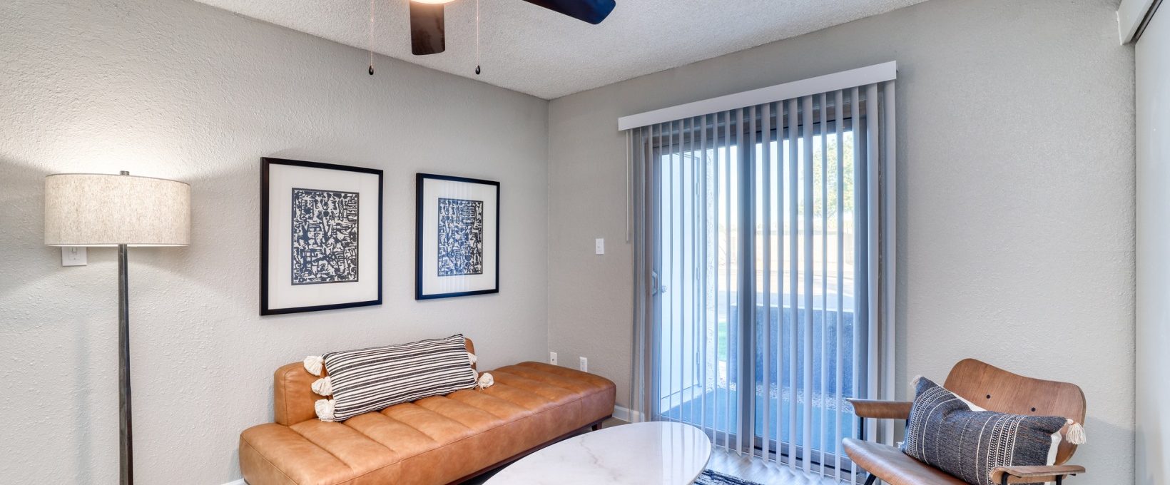 a living room with a ceiling fan and a couch at The Senara