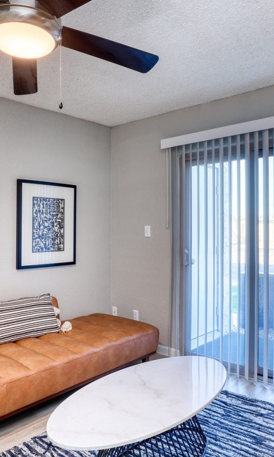 a living room with a ceiling fan and a couch at The Senara