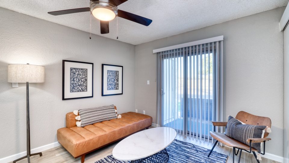 a living room with a ceiling fan and a couch at The Senara