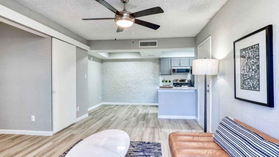 a living room with a ceiling fan and hardwood floors at The Senara
